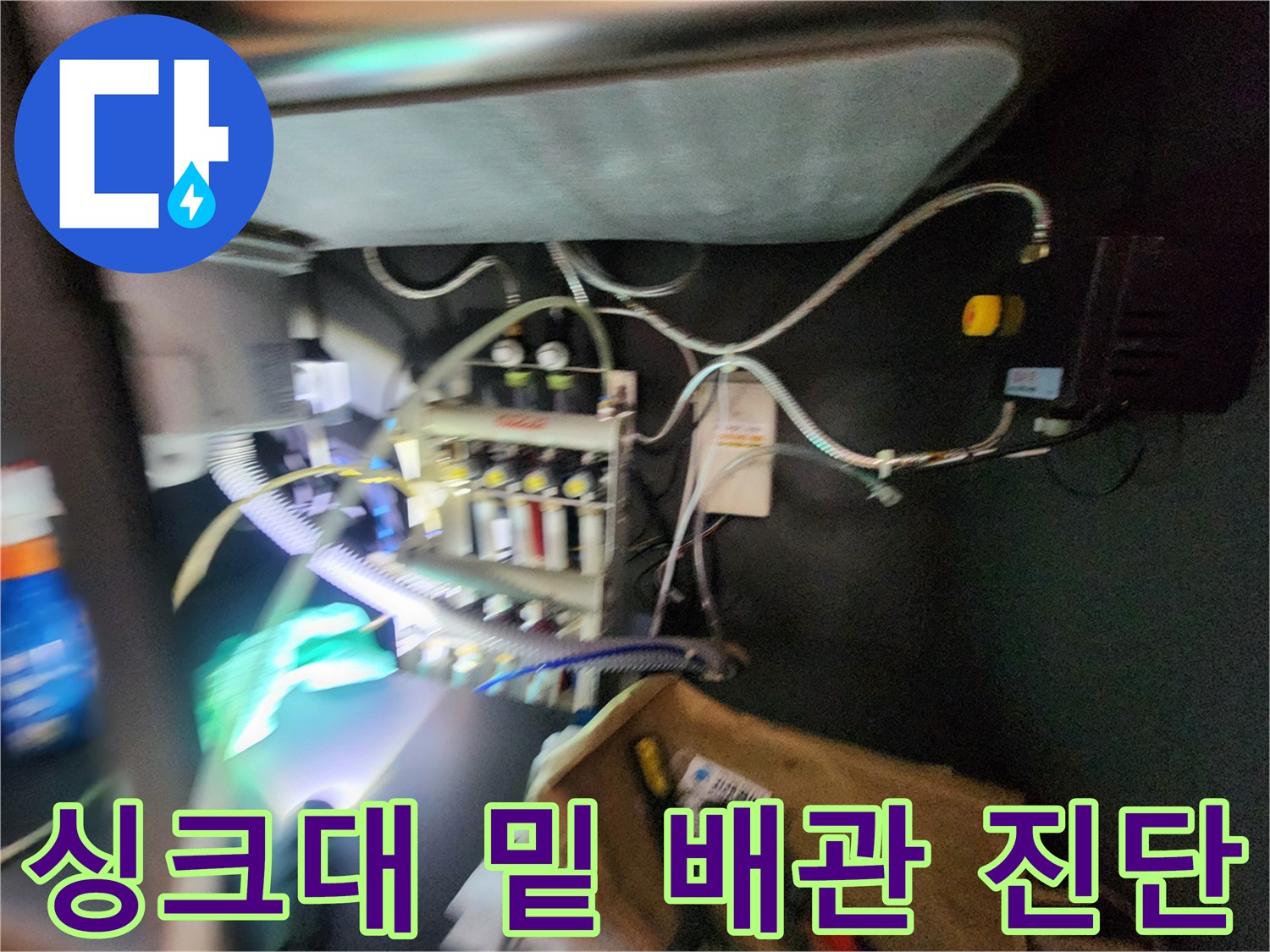 싱크대 아래 좁은 공간에 설치된 가스식 탐지 장비와 배관망