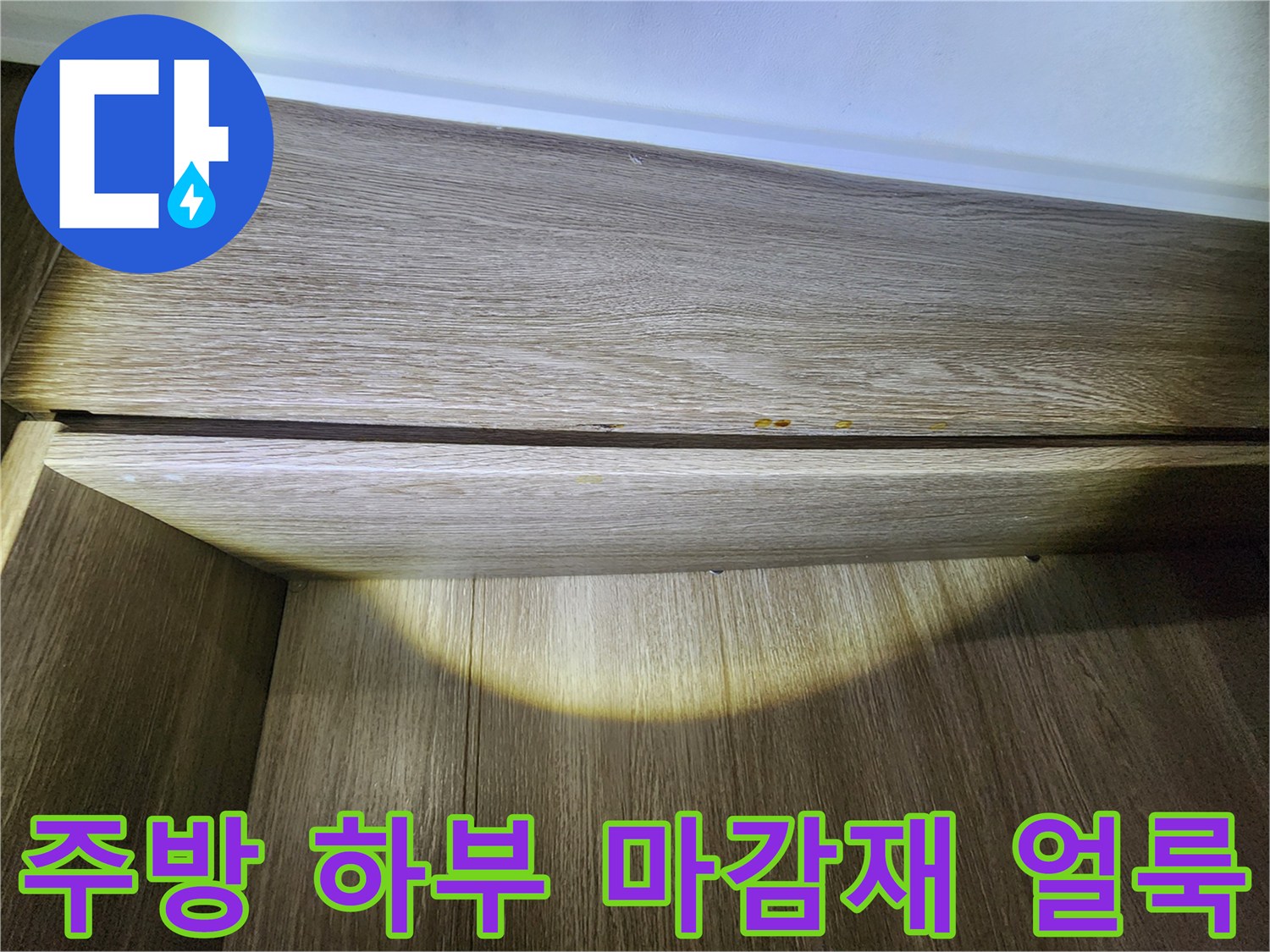 싱크대 하단 목재 부위의 누수 유입 흔적과 변색된 상태