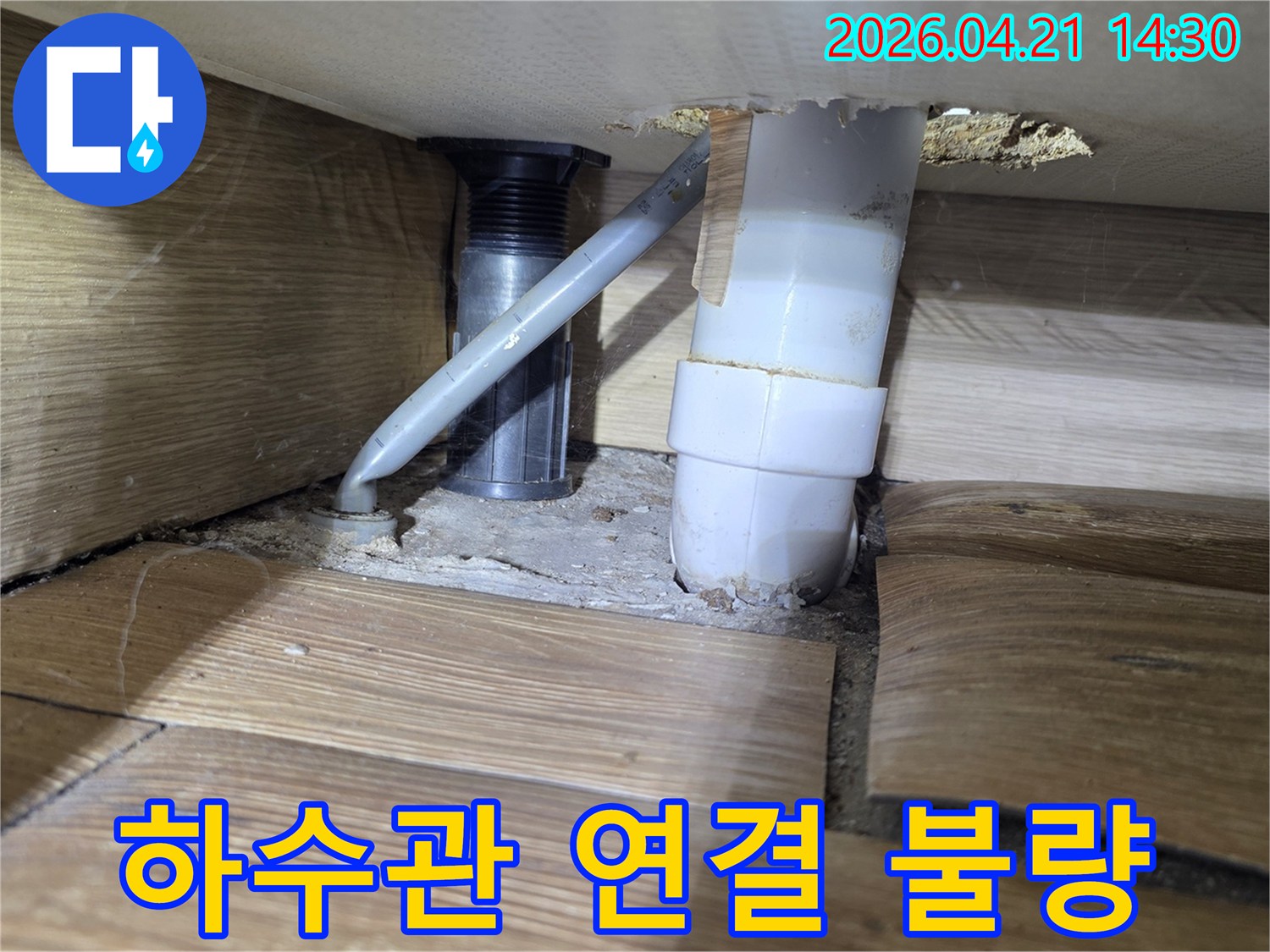 사무실 싱크대 하부의-하수관 연결 불량으로 인한-누수와 주변 바닥 손상