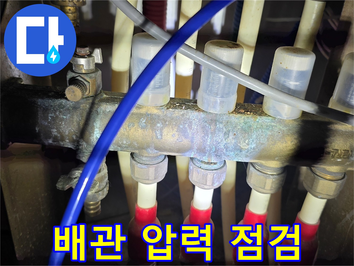 복잡한 배관 연결 부위에 공압 테스트기를 설치하여 누수를 확인하는 모습
