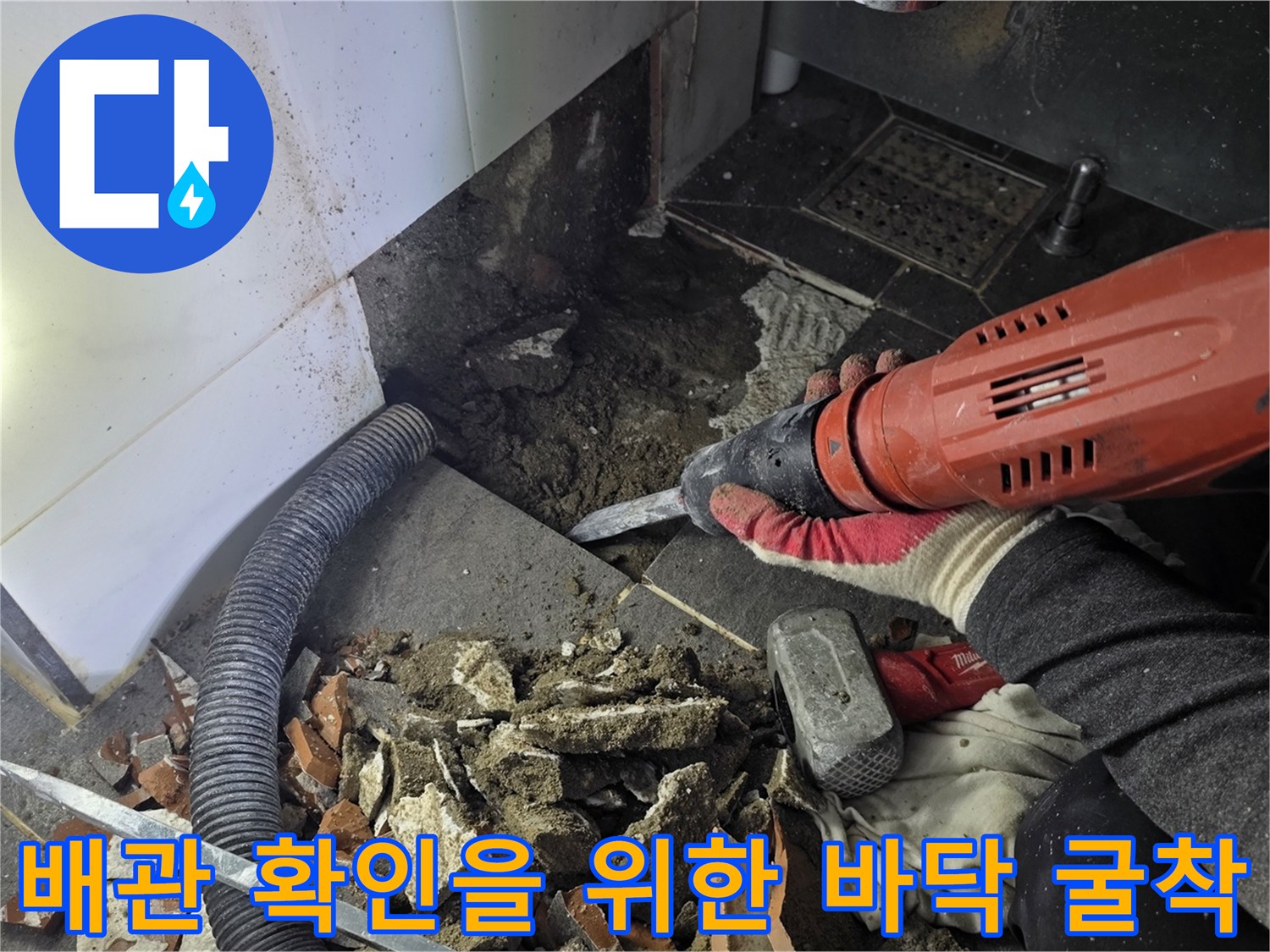 욕실 바닥 타일을 제거하고 배관 손상 부위를 노출시킨 현장 사진입니다.
