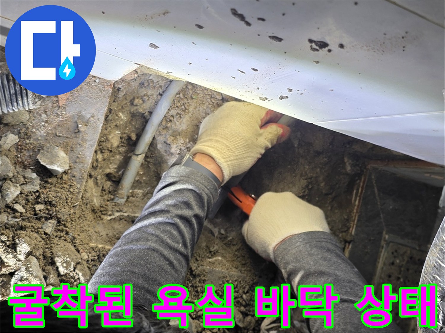 타일을 걷어내고 배관 확인을 위해 흙을 파낸 뒤 작업자가 점검하는 모습입니다.