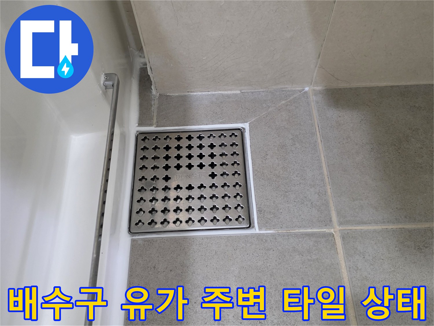 욕실 배수구 덮개와 인접 타일의 근접 사진