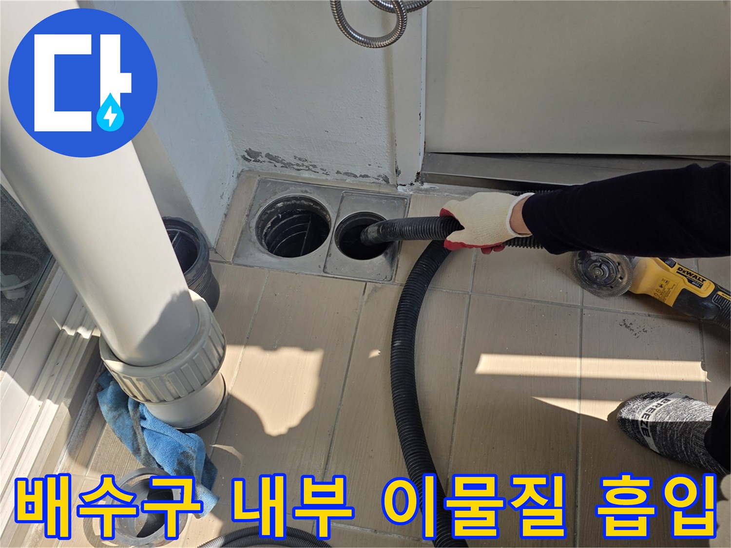 진공 장비를 이용해 배수관 입구의 오물을 제거하는 엔지니어의 작업