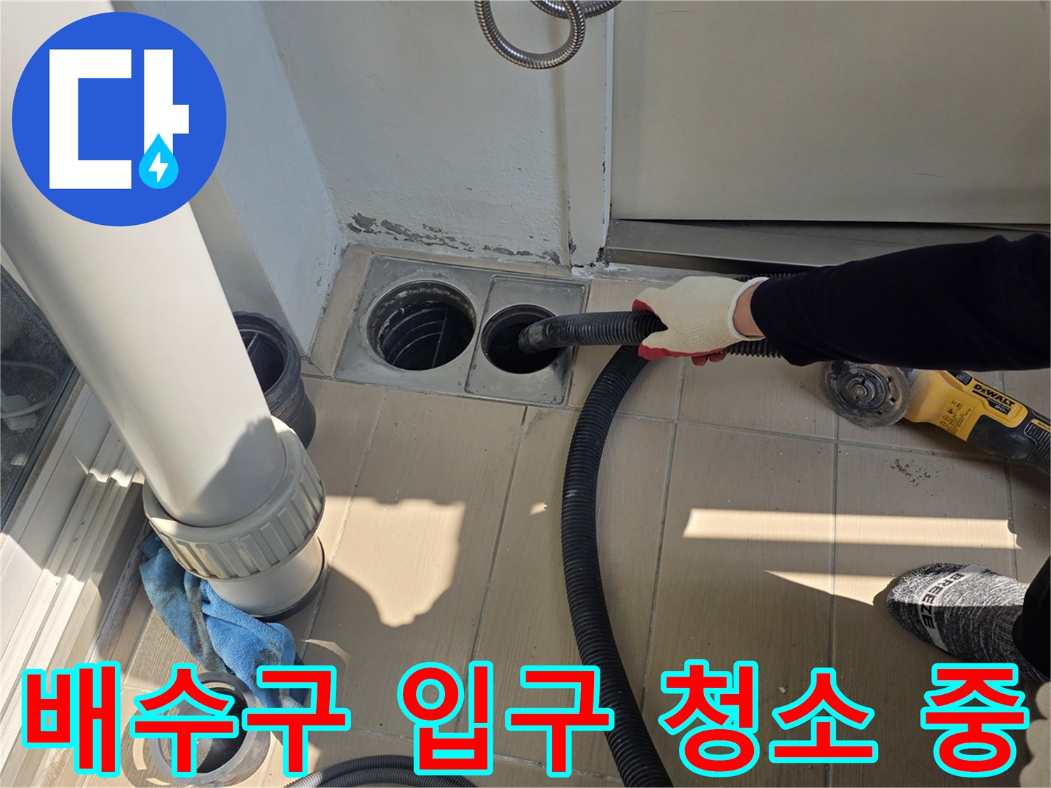청소기를 사용하여 배수구 주변의 잔여물을 정리하는 엔지니어