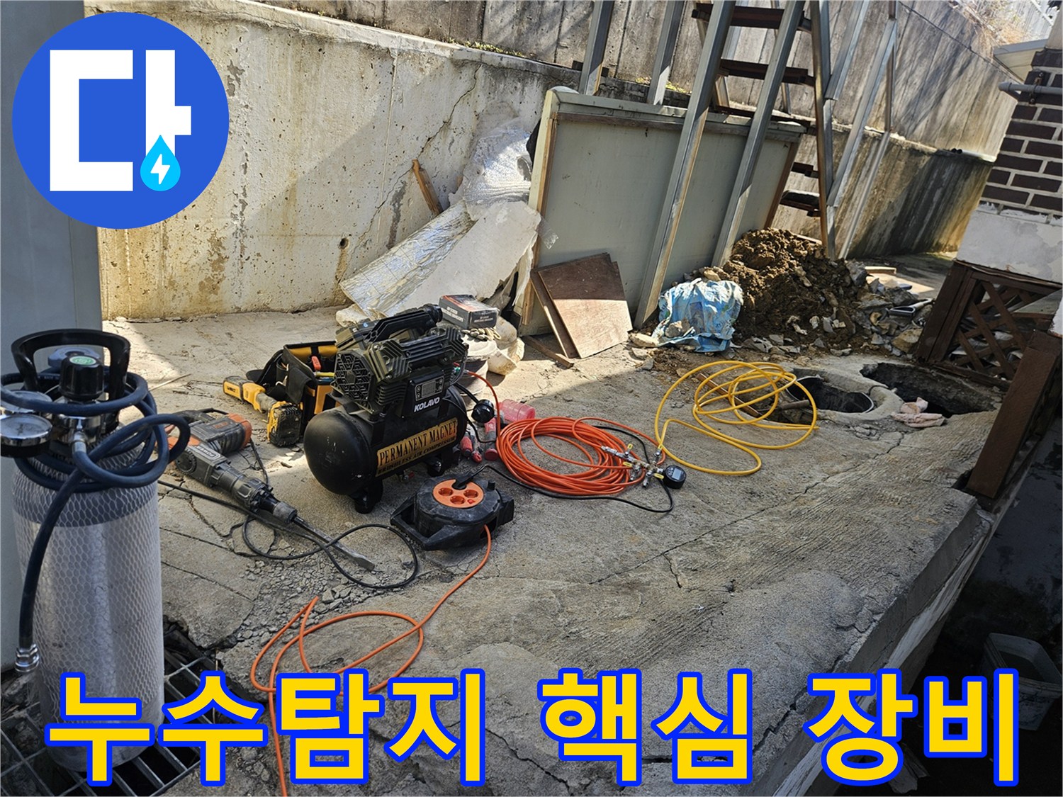 누수 공사를 위한-에어 콤프레셔-함마드릴-호스-전선릴 등-다양한 전문 장비들이-콘크리트 바닥 위에-정돈되어 있는-작업 준비 현장