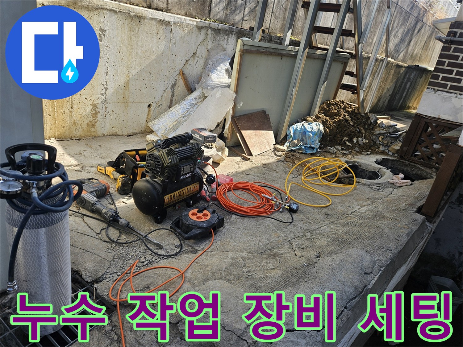 누수 공사를 위해-에어 콤프레셔-함마드릴-각종 호스 및 전선릴 등-필수 장비들이-콘크리트 바닥 위에-정돈된 채-작업 준비를 마친 모습