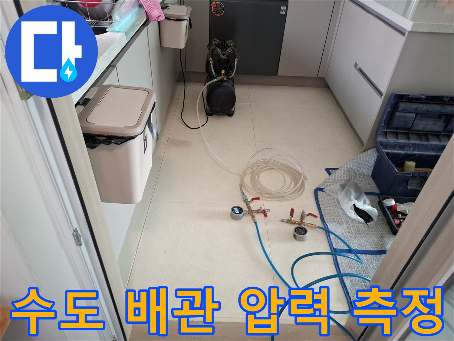 바닥에 놓인 수도 검사용 게이지와 연결된 파란색 호스