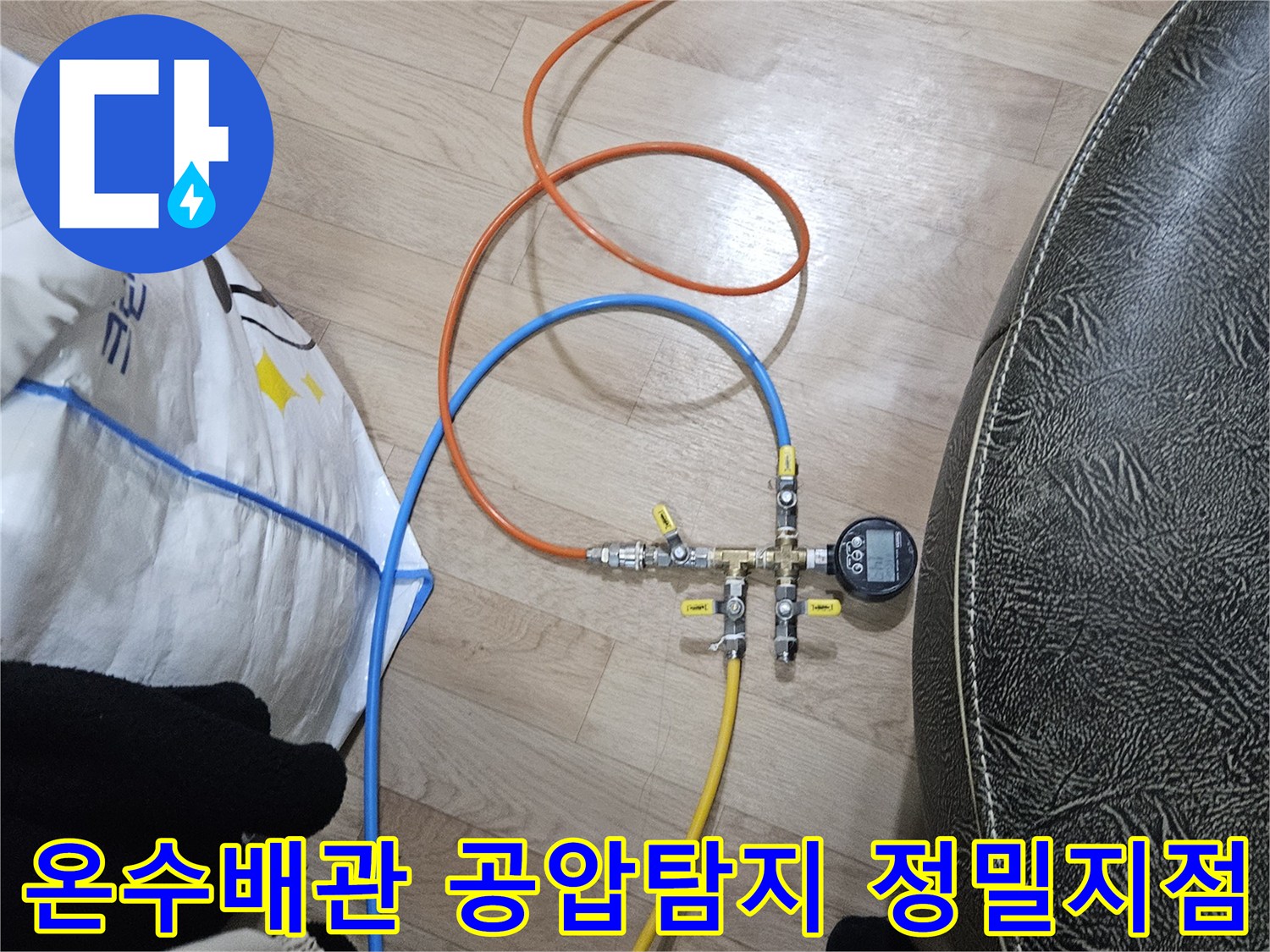 온수 배관의 누수 지점을 정밀하게 탐지하기 위해-공압 검사 장비가 연결되어 압력을 측정하는 모습입니다