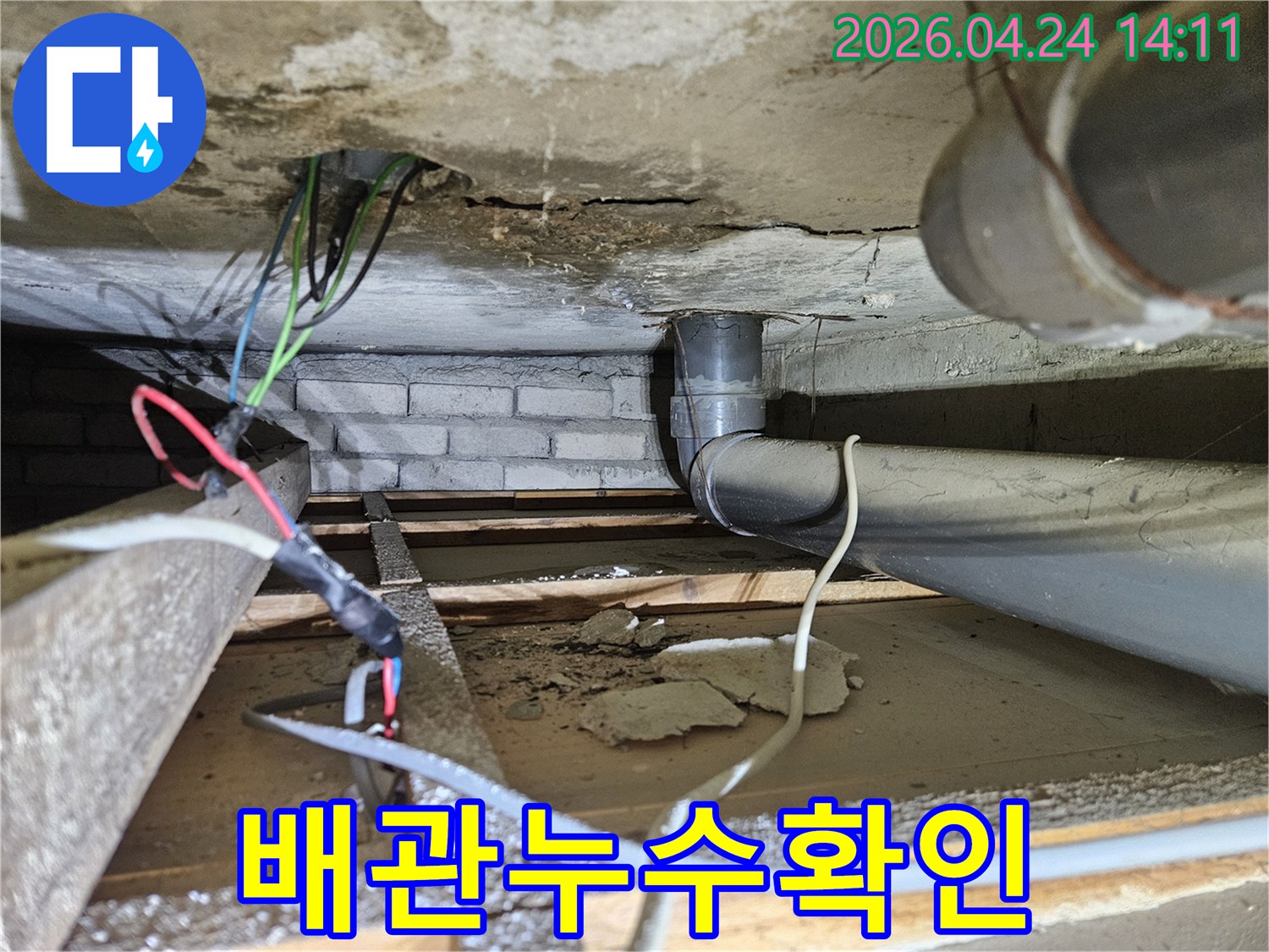 지하 공간의 배관 주변에서-오래된 누수 흔적과 함께-손상된 콘크리트 구조물을 보여주는 이미지입니다