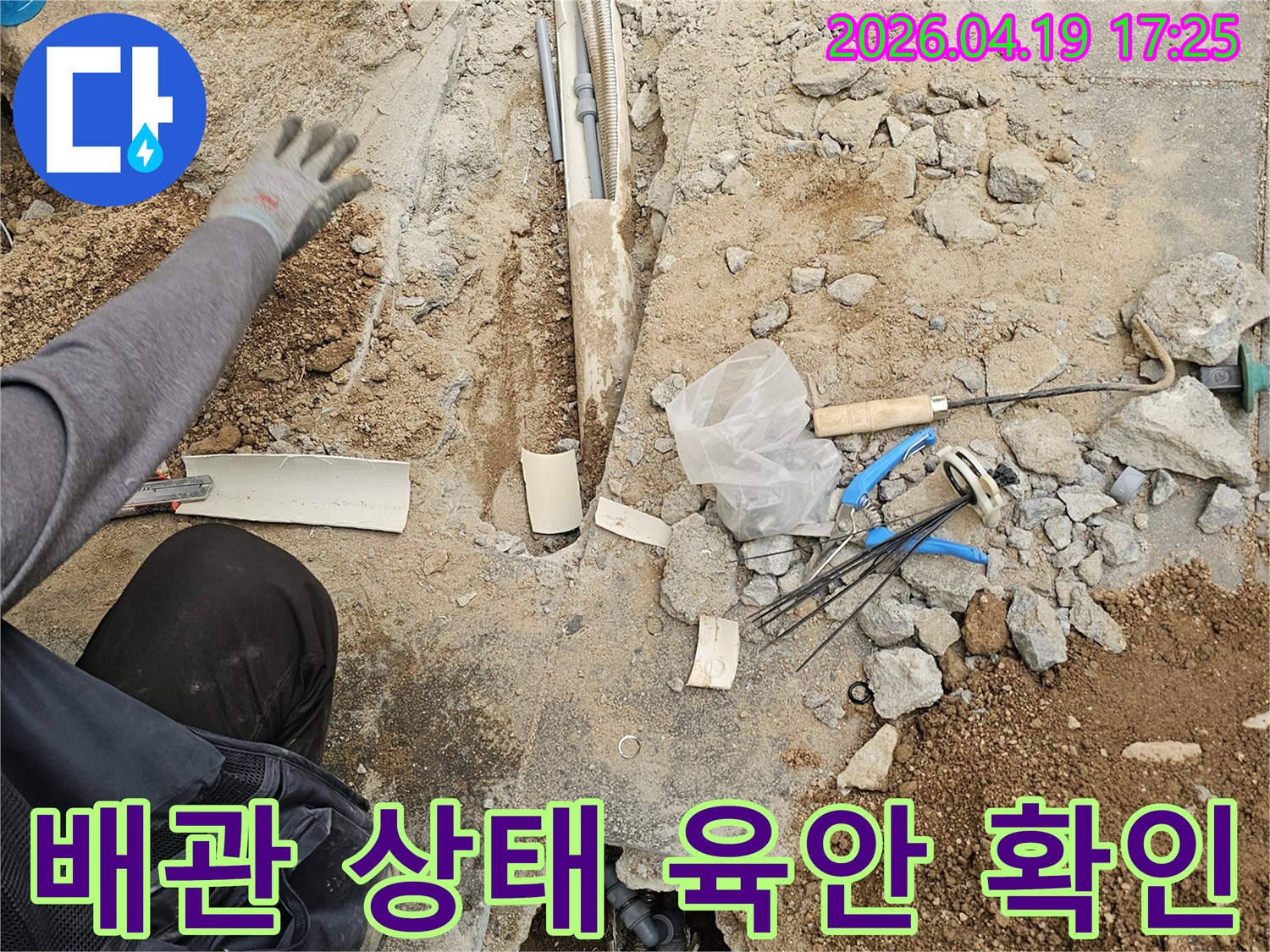 누수 공사 현장에서-바닥 파쇄 후-노출된 배관의 상태를-전문가가 육안으로 확인하는 모습
