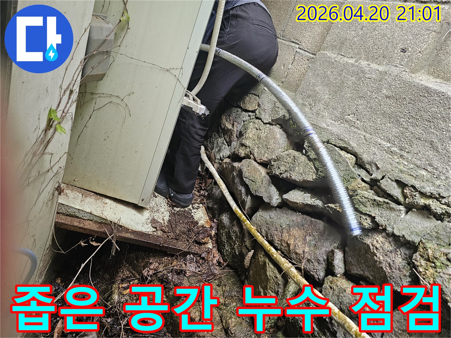 건물 외벽 아래-협소한 공간에서-누수 지점을 찾아내기 위해-탐지 작업을 진행하고 있습니다.