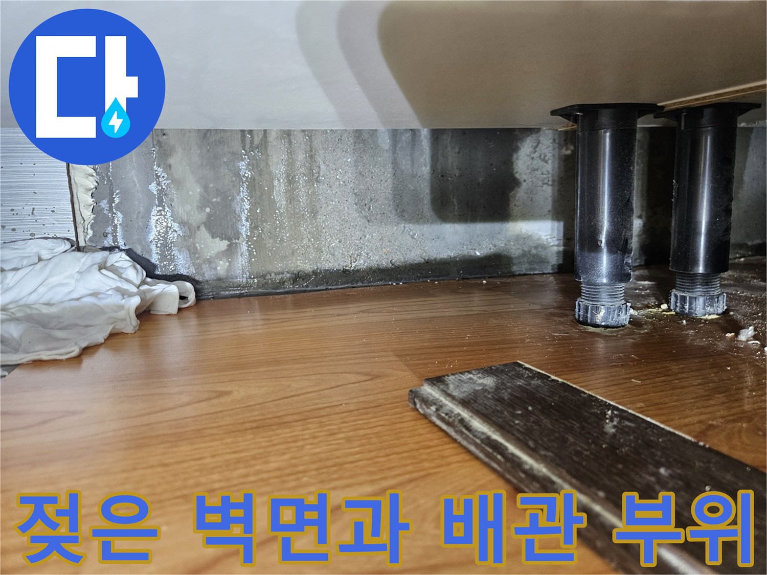 싱크대 밑바닥 벽면에 남은 물자국과 오염된 상태의 배관