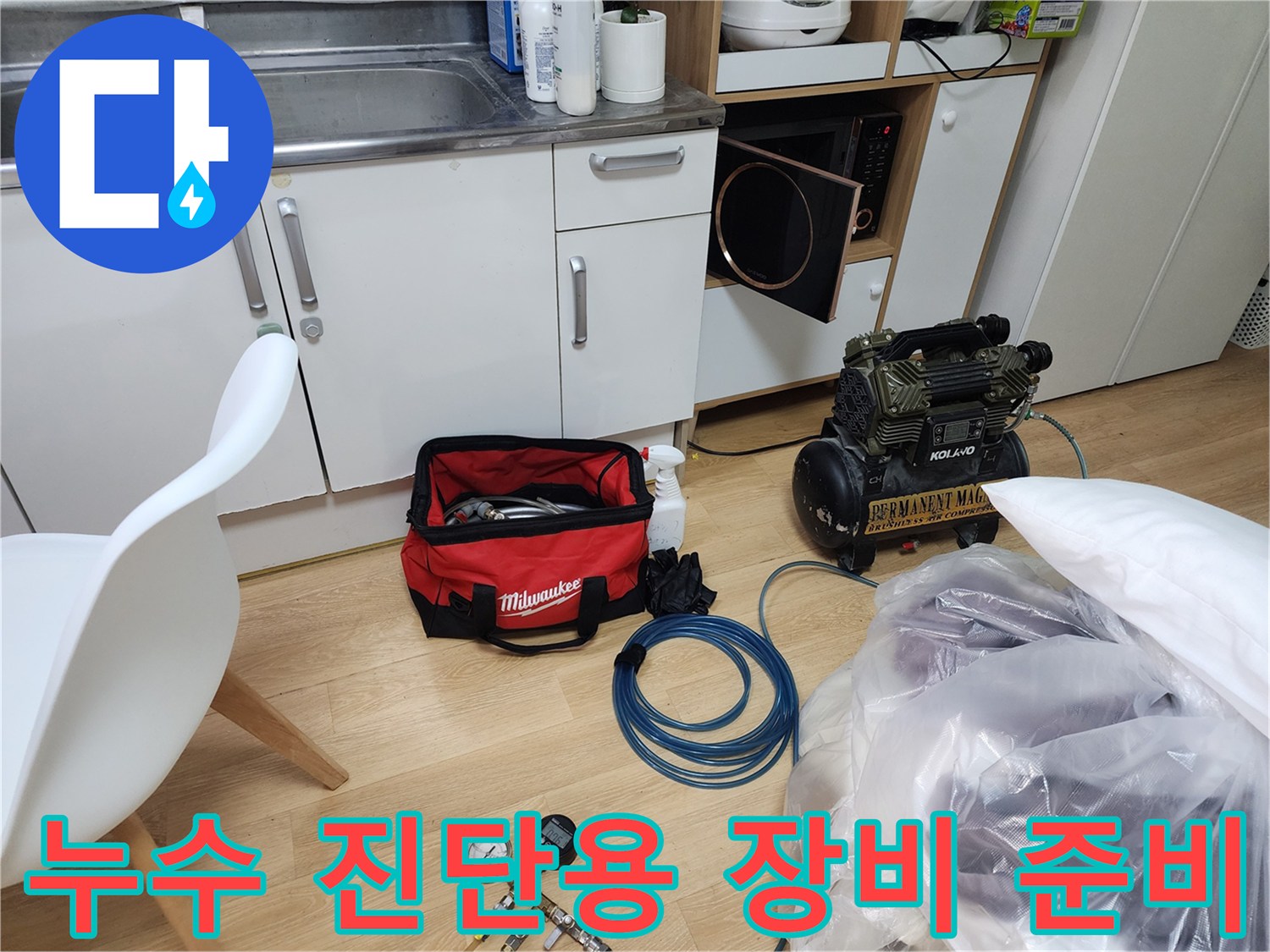 싱크대 하부 작업장에 배치된 디지털 압력계와 공구 및 측정 도구들