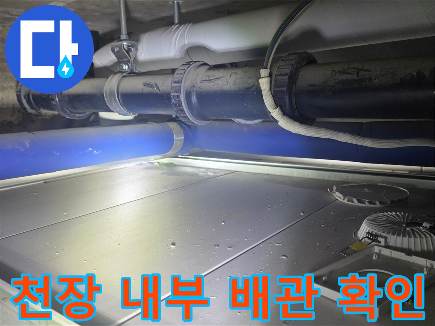 천장 점검구 안쪽의 배관 연결 부위 근접 촬영