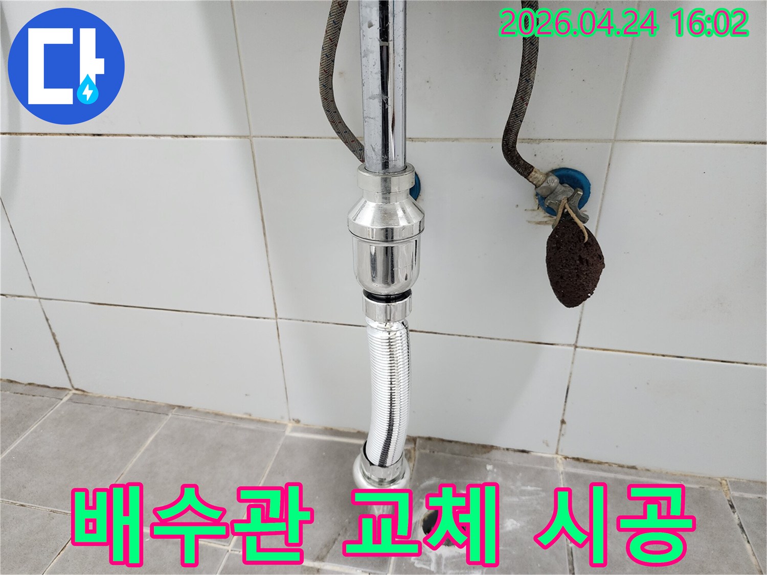 욕실 세면대-아래의-새로 설치된-배수관과-주변 환경을-담고 있습니다.