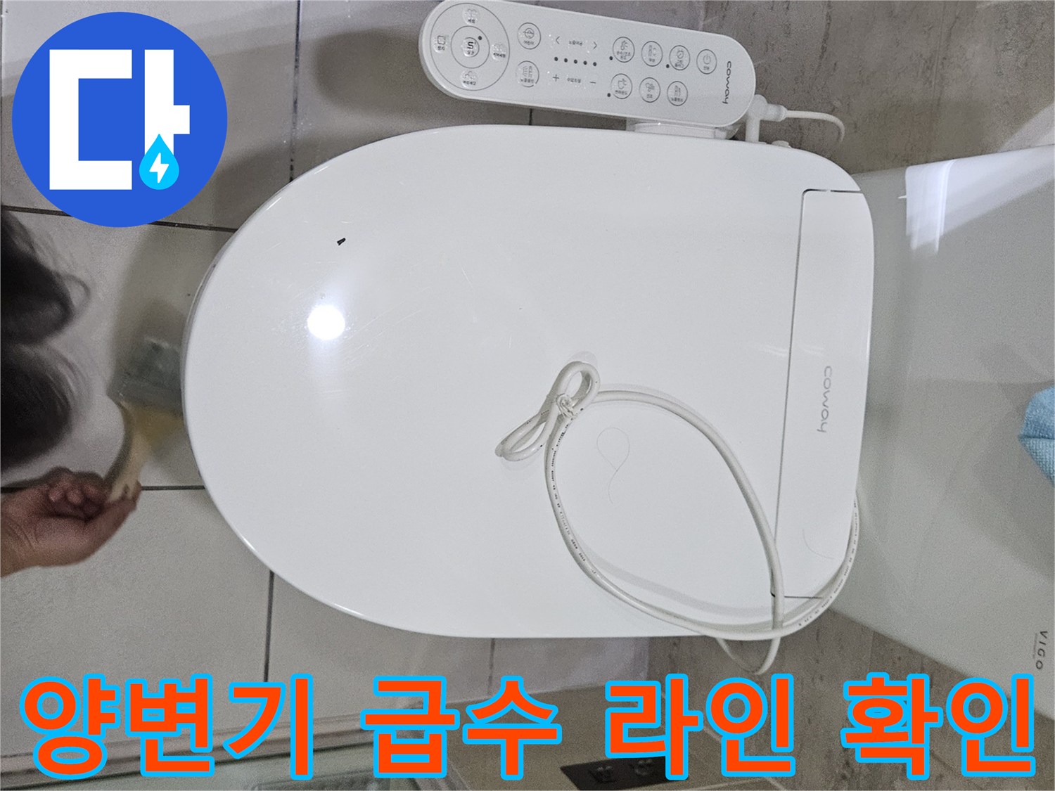 양변기에 연결된 비데 전선과 바닥 타일의 모습