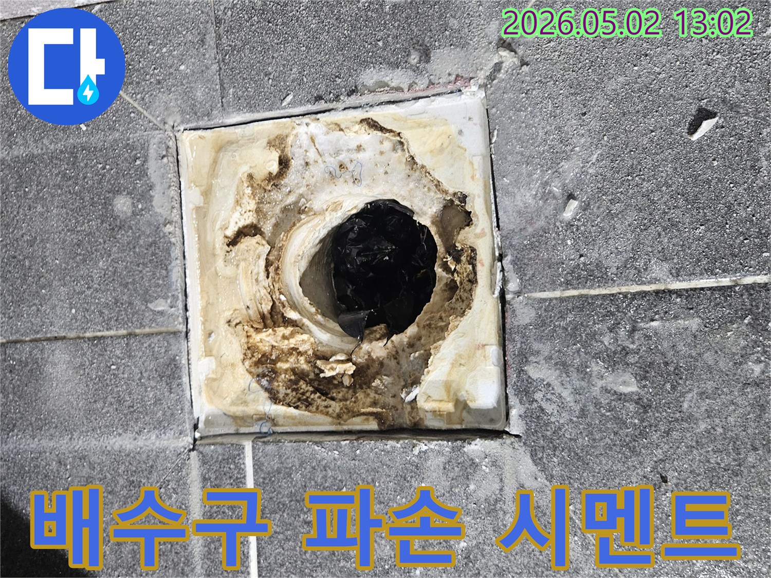 욕실 배수구 주변의-파손된 시멘트가-누수로 인해-더욱 심각해진-현장을 보여주는 사진입니다