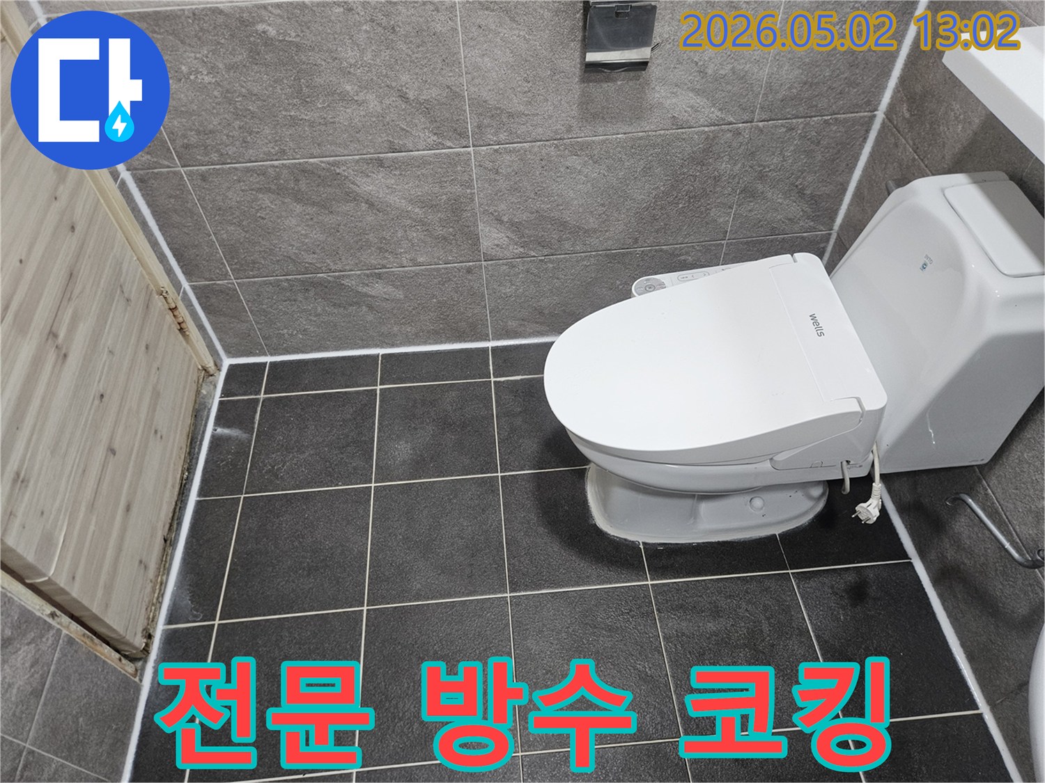이 이미지는 욕실 변기 주변과 바닥-벽 타일 경계면에 새로 시공된 깨끗하고 전문적인 실리콘 코킹 마감 상태를 보여줍니다.