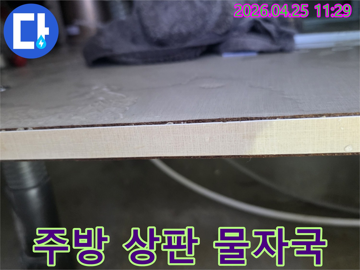 주방-싱크대-상판에-물이-스며들어-생긴-얼룩과-변형을-보여주는-이미지