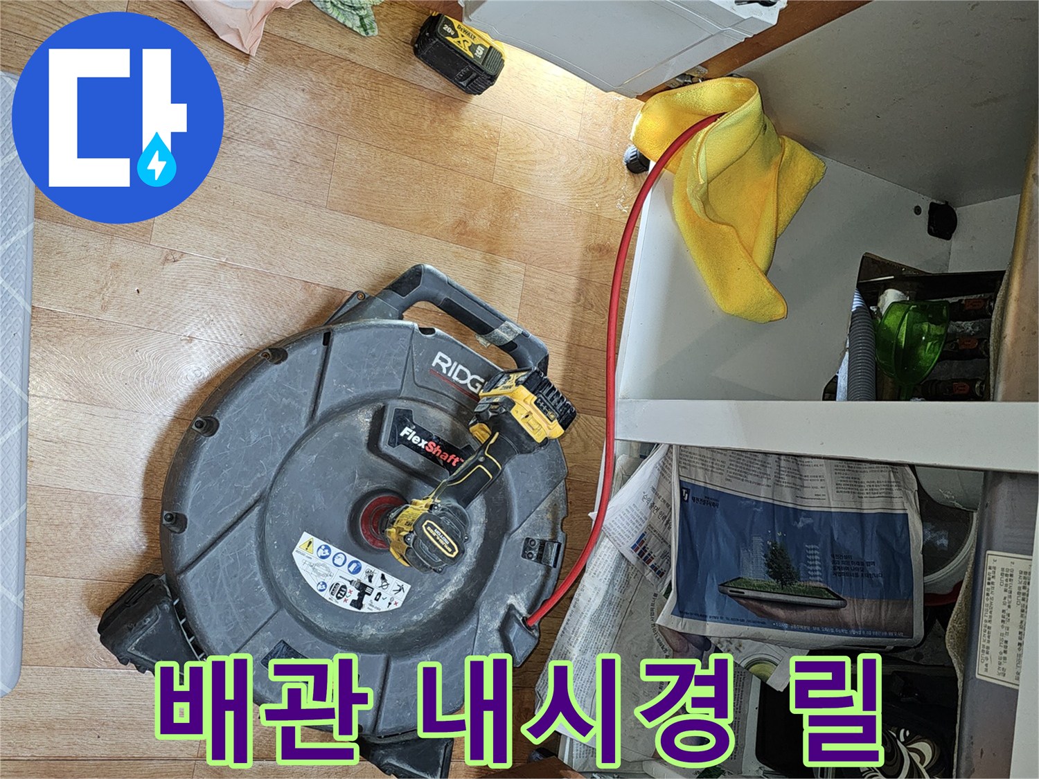 싱크대 아래 공간에 놓인 배관 검사용 내시경 카메라 릴