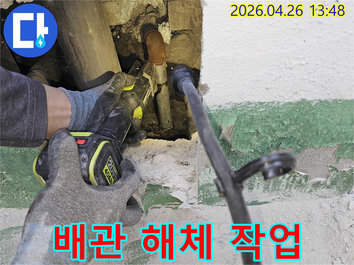 누수 전문 엔지니어가-벽 속에 숨겨진-손상된 배관을-전동 공구로-조심스럽게 잘라내고 있습니다.