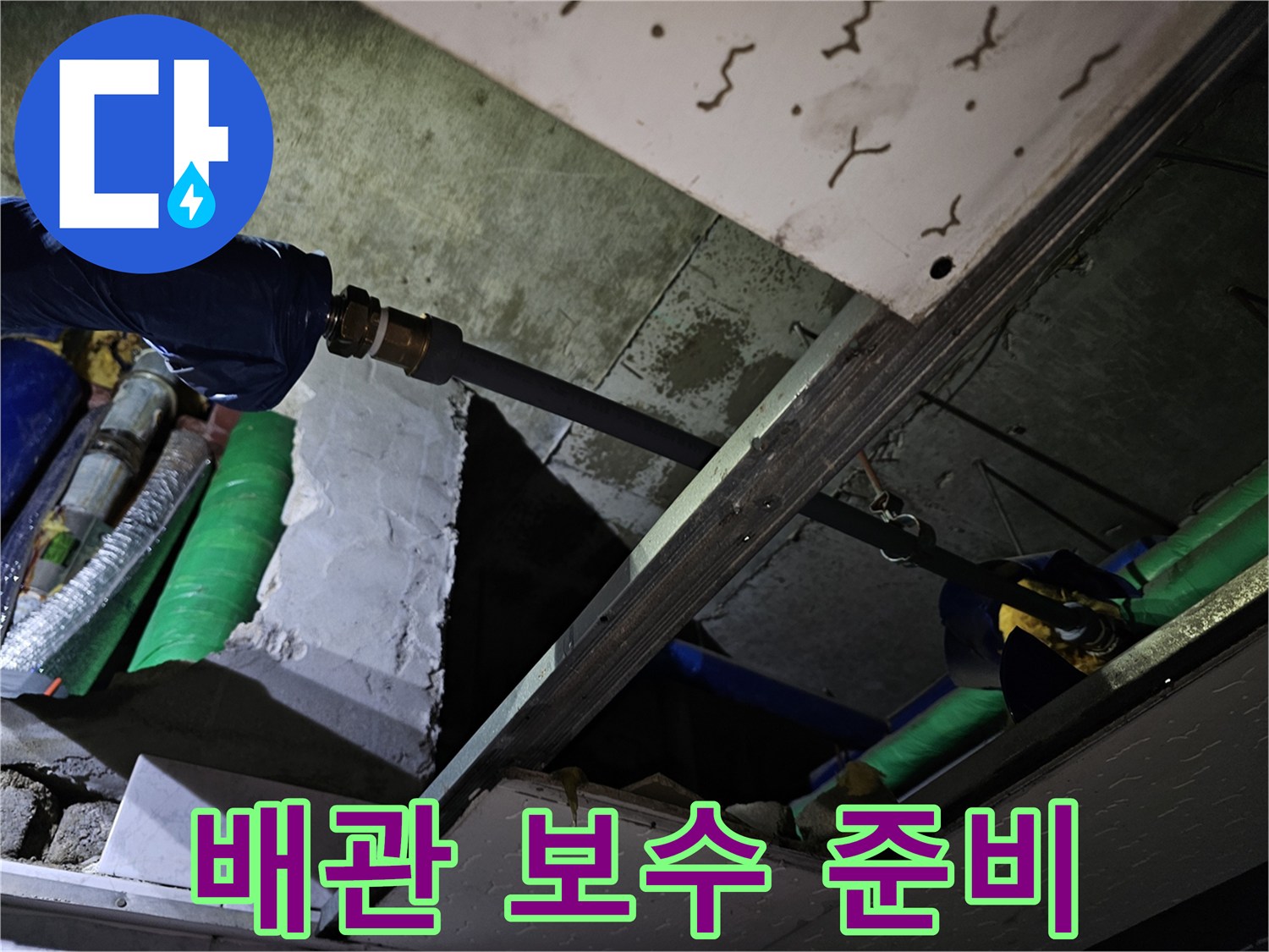 누수 발생 배관의 연결 부위를 보수하기 위해 주변을 정리하고 준비하는 현장입니다.