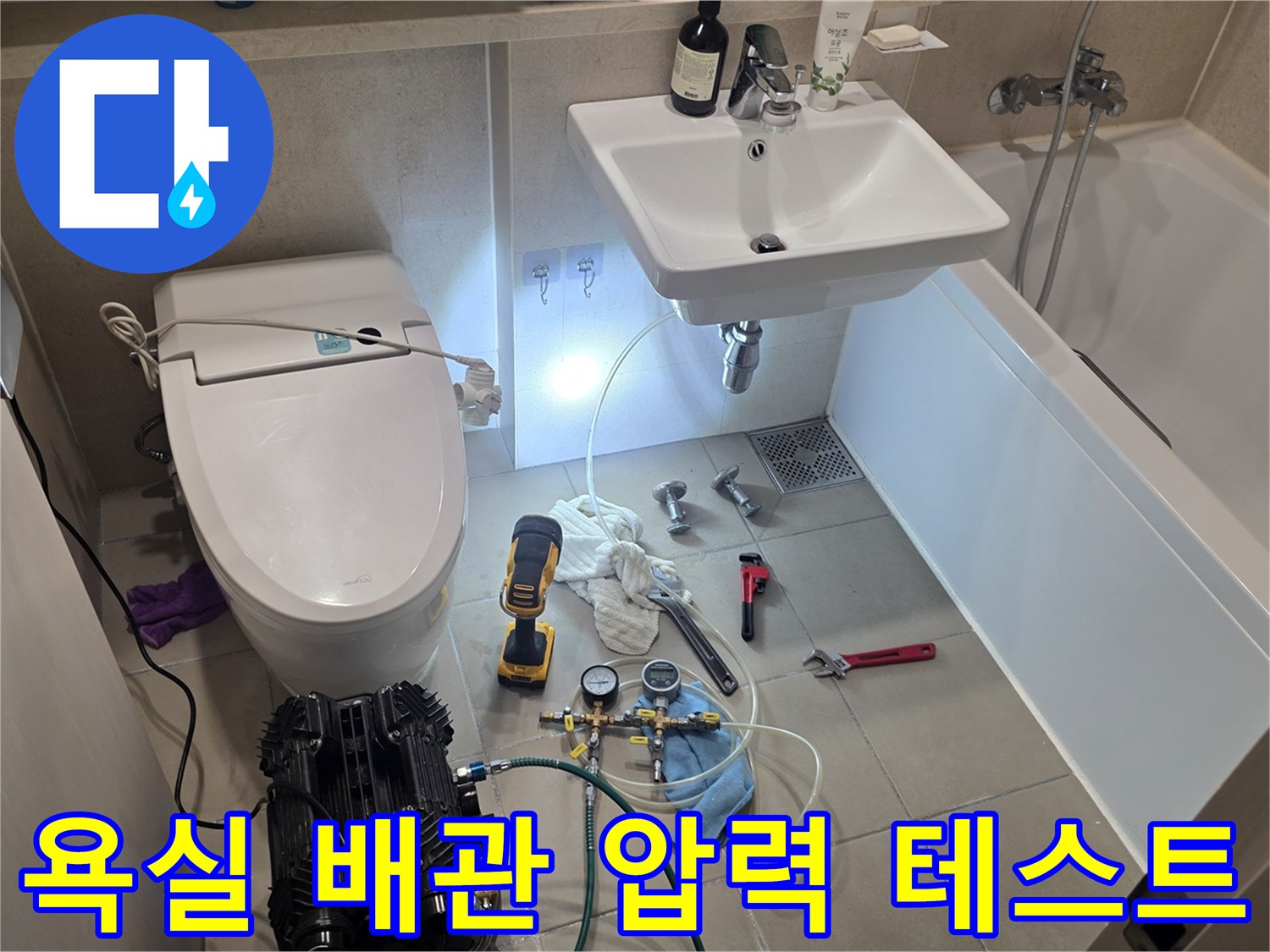 수도 배관의 기밀성을 확인하기 위해 설치된 공압 측정 장비와 작업 도구