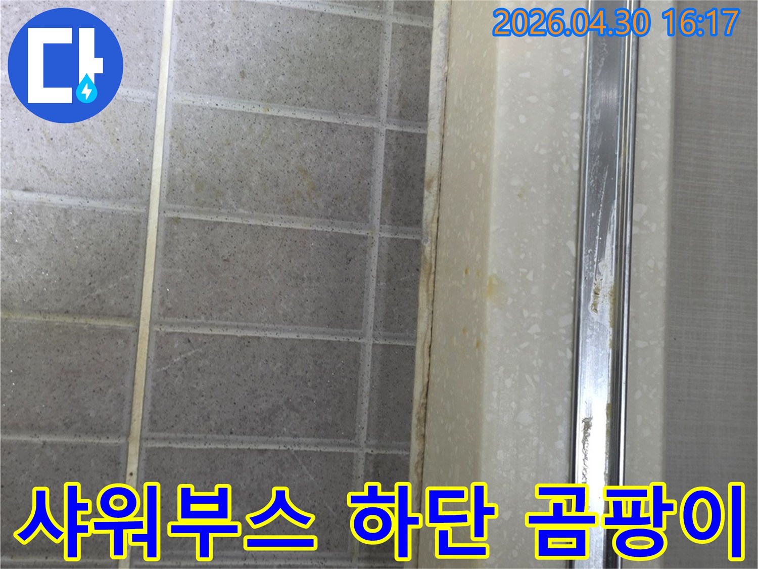 샤워부스 하단부 타일과-경계면에 곰팡이와-오염이 발생한 상태를 보여줍니다