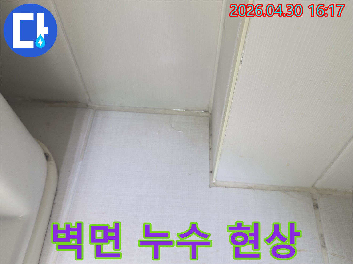 천장과 벽이 만나는 지점에서 물이 고여-벽지가 젖어있는 상태를 보여주는-누수 발생 현장 사진