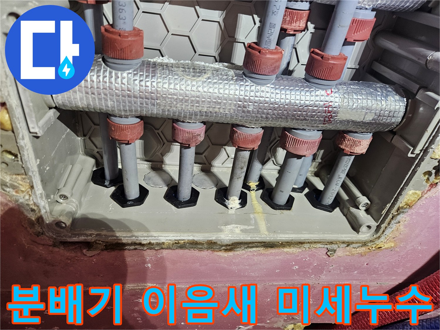 수도 분배기 이음새 부위에서-미세한 누수 여부를 확인하는 모습