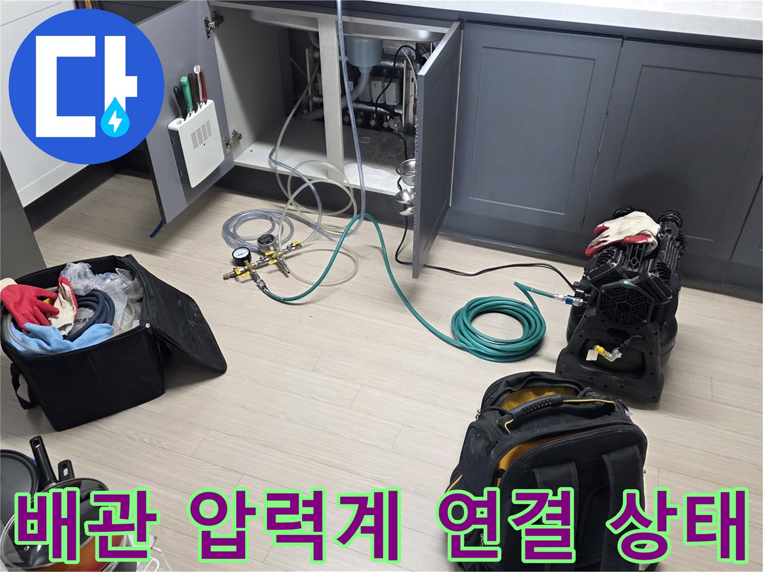 싱크대 하부 배관에 설치된 디지털 압력계와 공압 테스트용 호스 모습