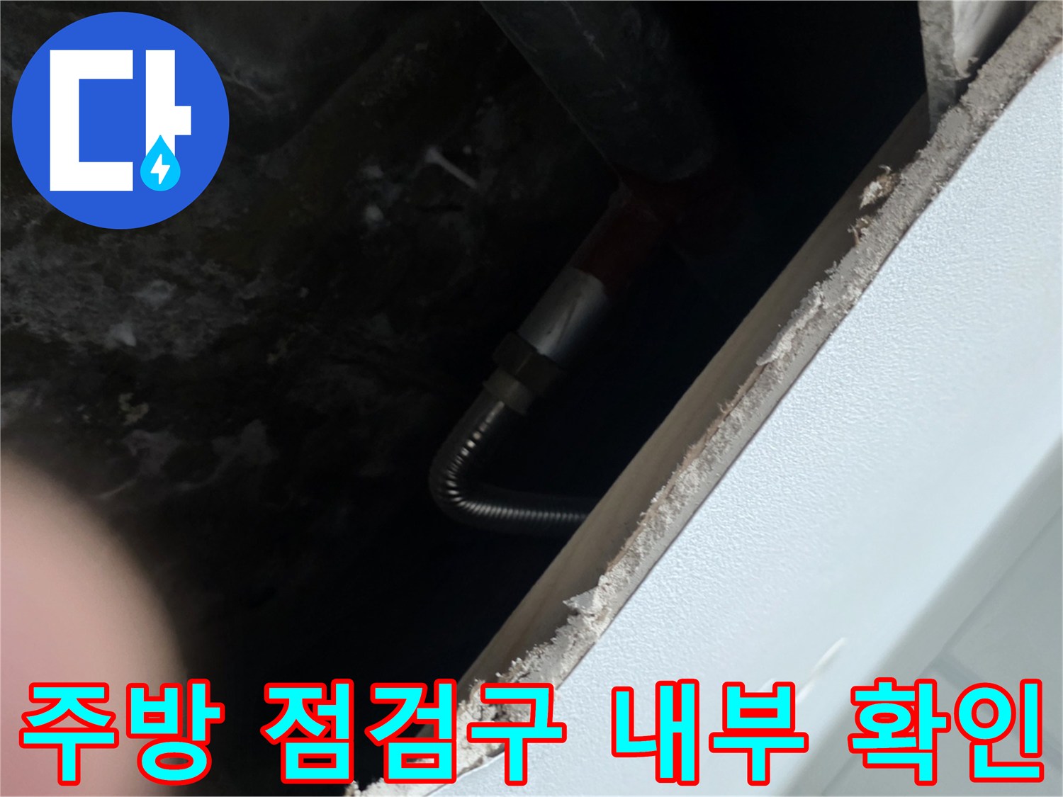 안양 동안구 아파트 주방 하부장 점검구 내부의 젖은 콘크리트와 배관 상태