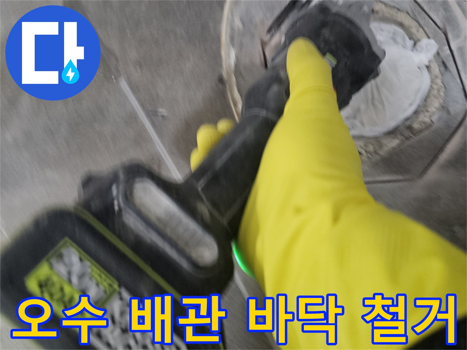 노란색 작업 장갑을 착용한-기술자가-전동 공구로-오수 배관 주변의 바닥을-조심스럽게 철거하는 모습입니다.