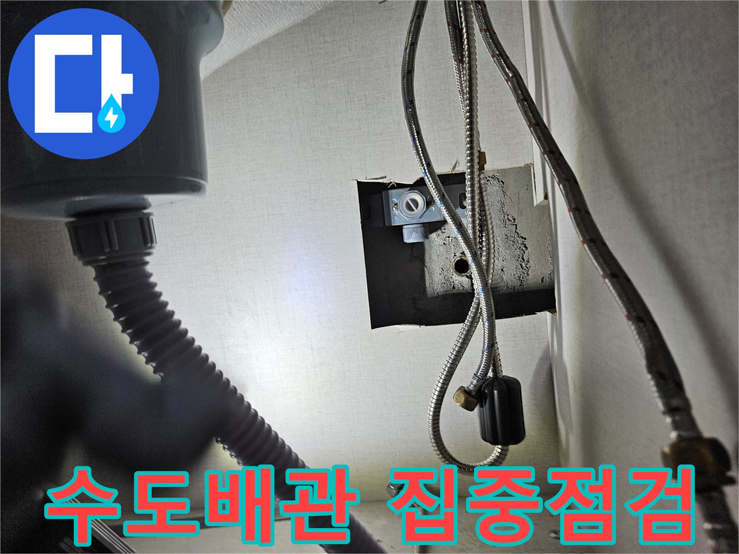 싱크대 하부장 내부의-수도 배관 연결 부위를-집중적으로 점검하며-누수 여부를-확인하는 장면입니다.