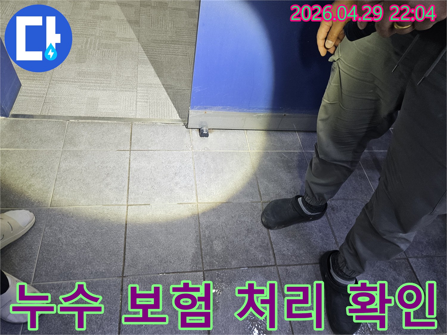 누수 전문가가 바닥에 고인 물기를 확인하며-누수 보험 처리 가능 여부를 판단하기 위한-초기 진단을 진행하고 있습니다.