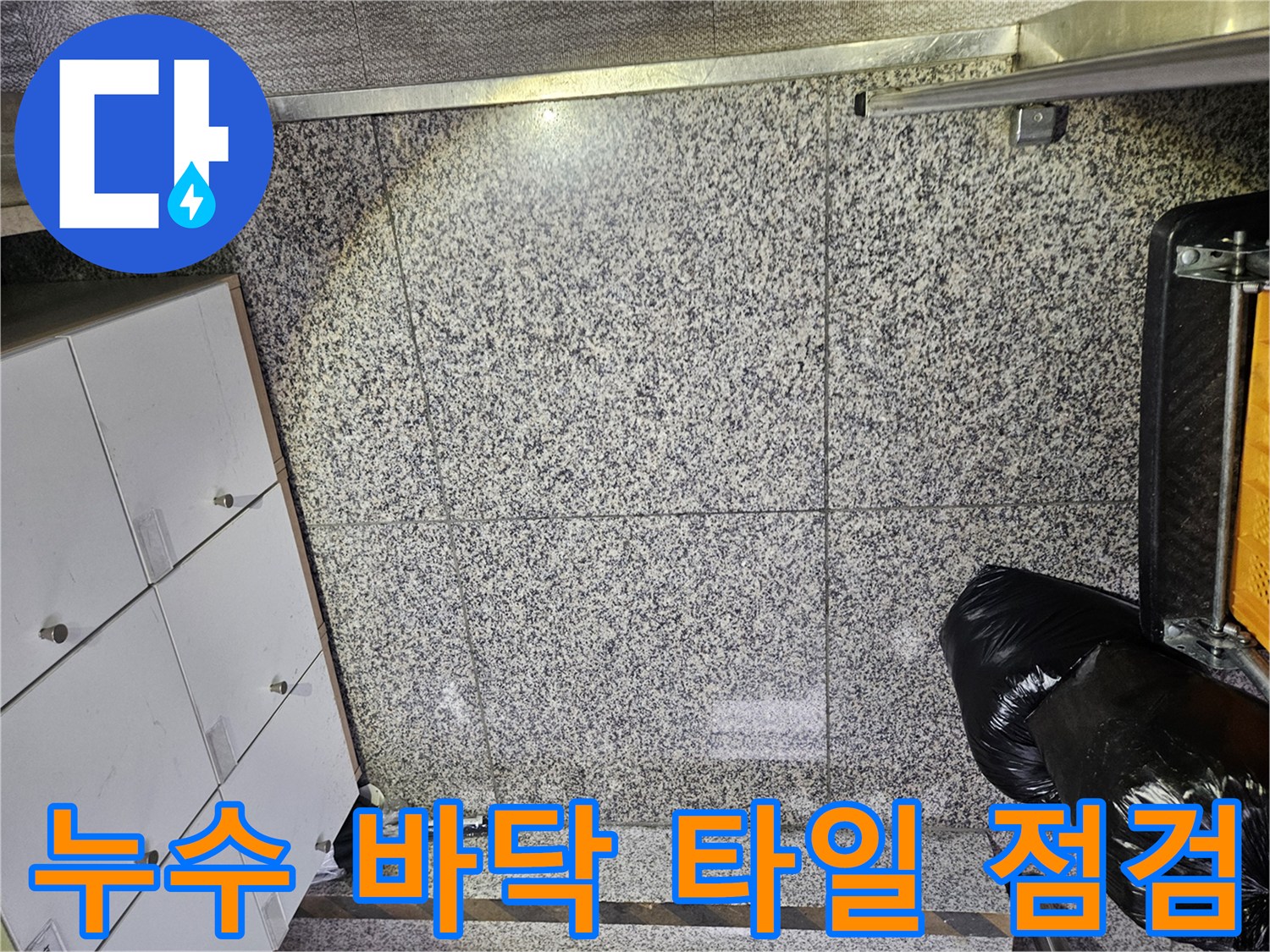 포천 아파트의 바닥 타일에서-누수로 인한 물기 흔적을 발견하고-정확한 누수 지점을 찾기 위한-전문가의 면밀한 점검이 이루어지고 있습니다