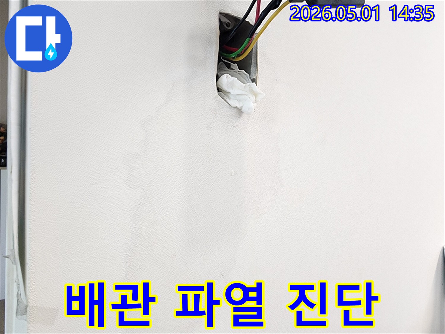 벽면의-누수-흔적과-젖은-벽지-그리고-콘센트-주변의-물기를-통해-배관-파열을-의심하는-모습