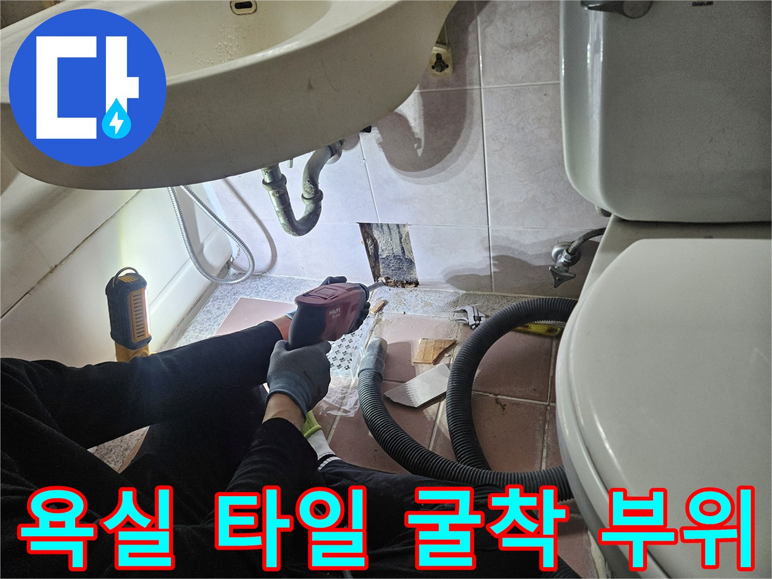 세면대 근처 타일을 제거하여 내부 배관 상태를 점검하는 사진