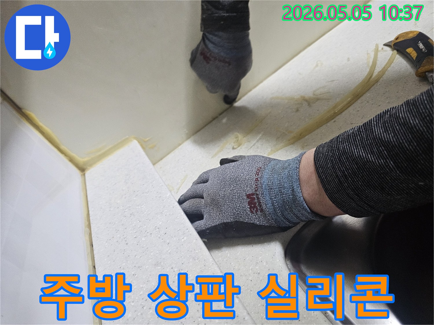 숙련된 전문가가 주방 상판 틈새 누수를 해결하기 위해-오래된 실리콘을 제거하고-새로운 방수 실리콘으로 교체하는 작업 현장입니다
