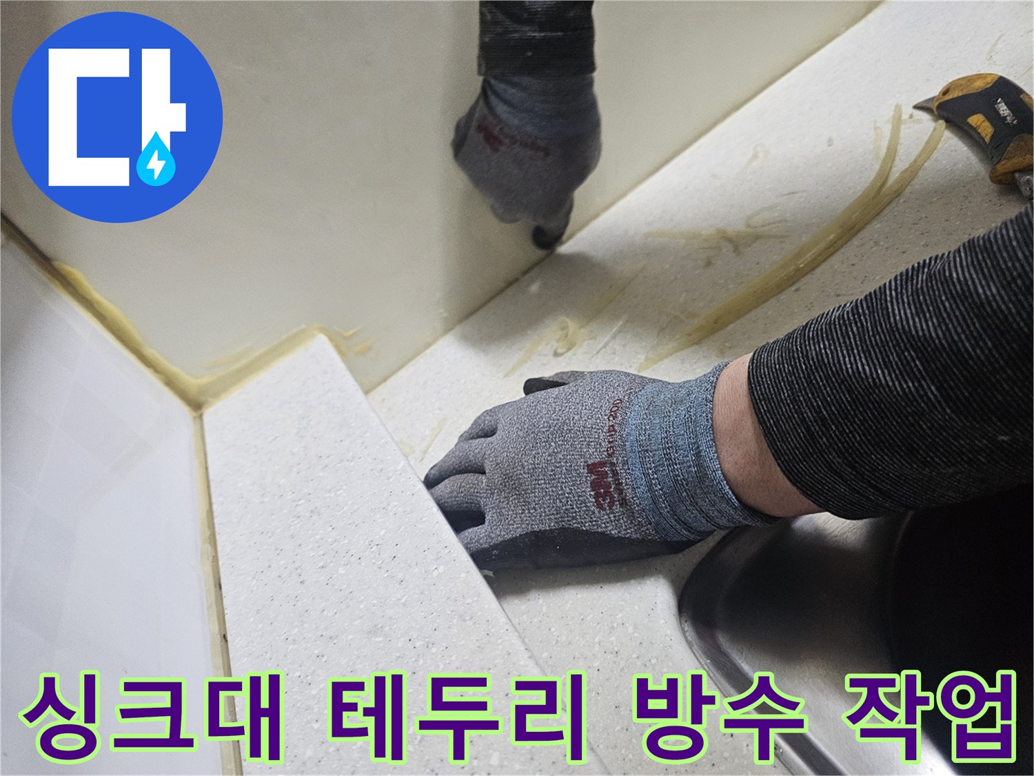 엔지니어가 장갑을 끼고 싱크대 틈새를 실리콘으로 메우는 장면