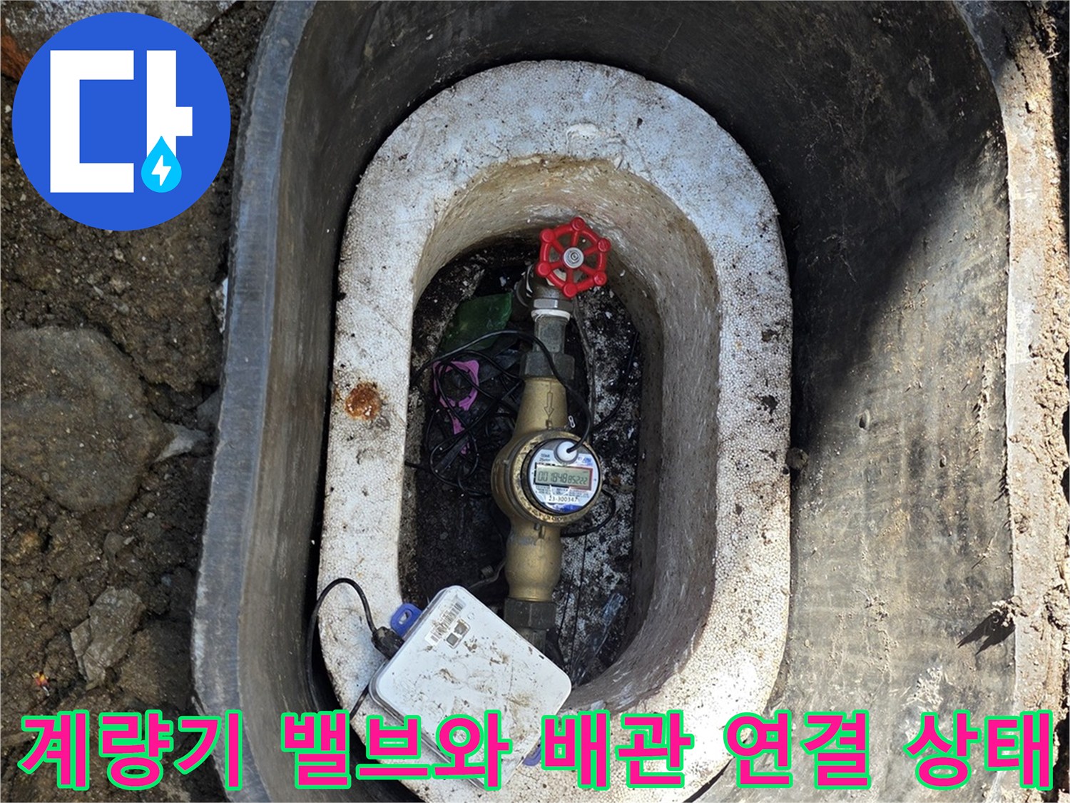 붉은색 밸브가 장착된 수도 계량기함의 내부 사진