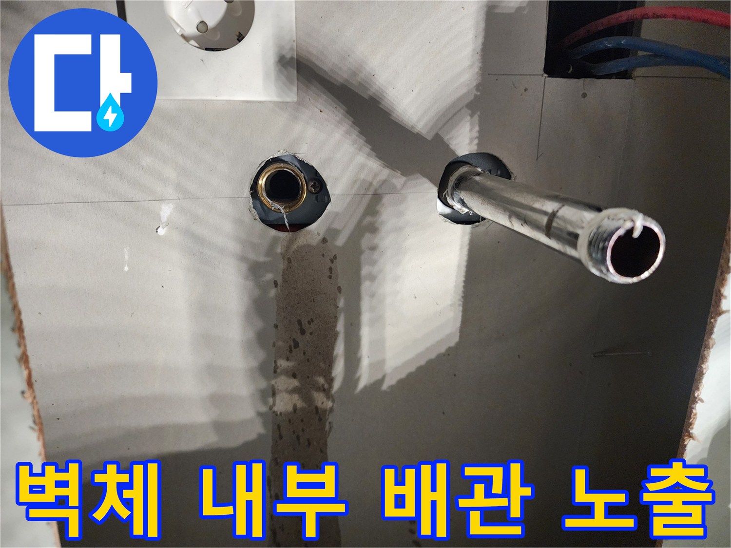 싱크대 벽면 굴착-노출된 금속 배관과 파란색 배관의 연결 상태