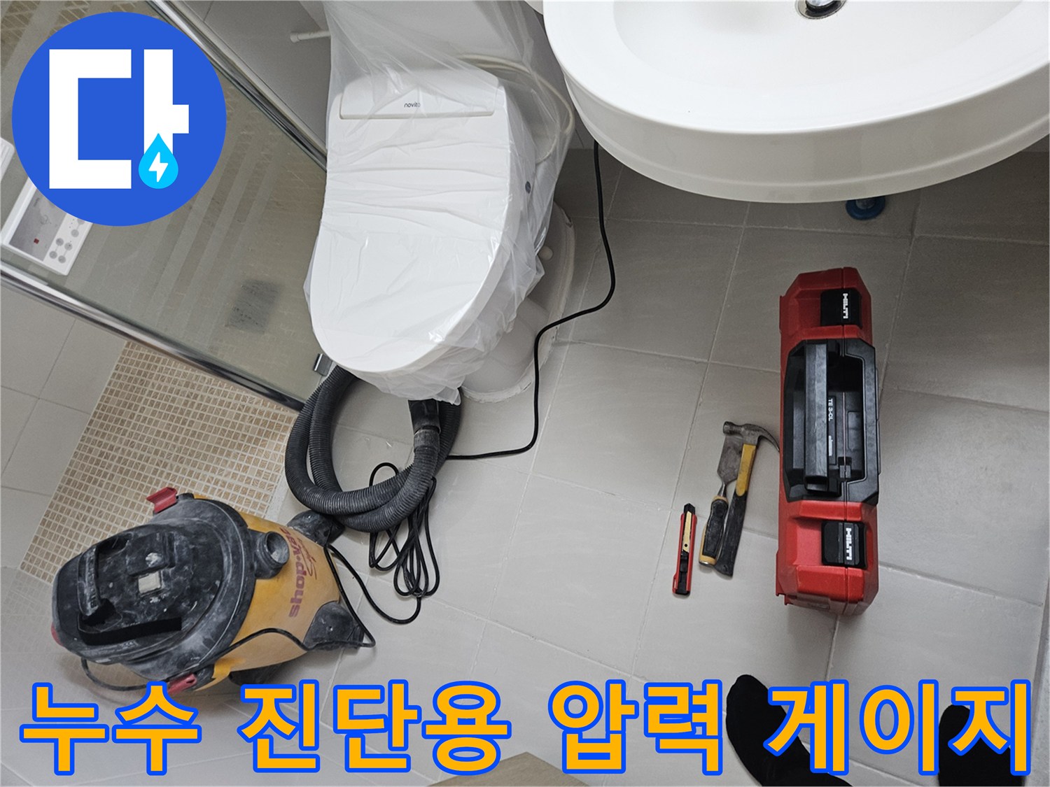 바닥 타일 위에 놓인 배관 점검 장비와 청소 도구 세트