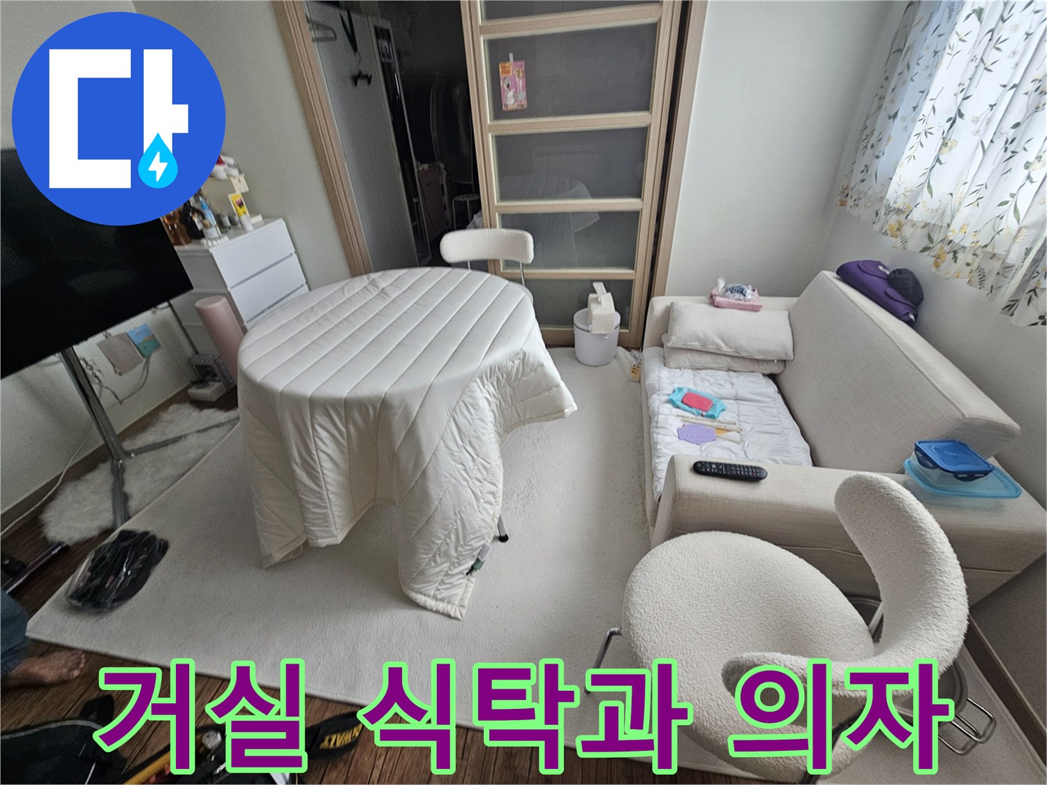흰색 식탁과 의자가 배치된 거실 내부 모습입니다.
