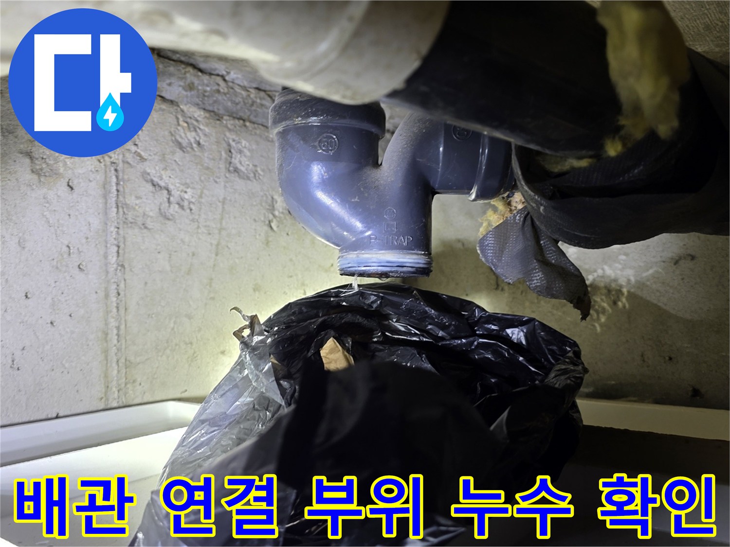 세면대 아래쪽 엘보 배관과 수직 배수관의 접합 지점 근접 촬영
