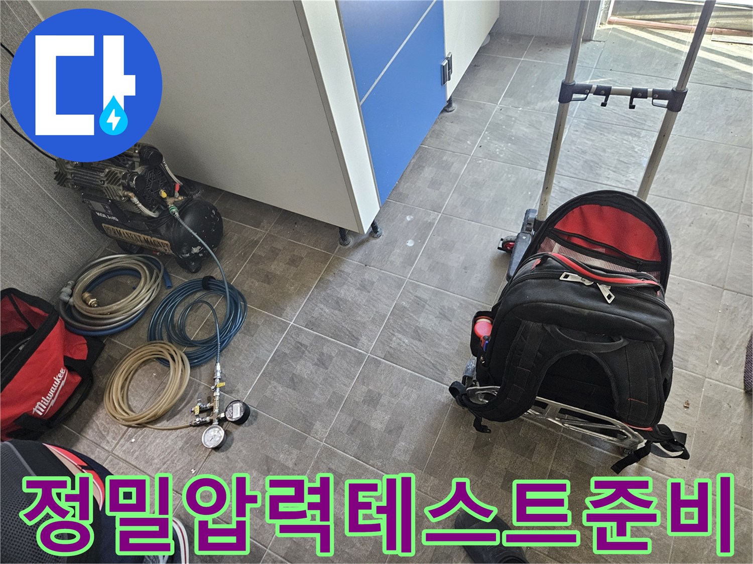 누수 공사를 위한-정밀 압력 테스트 장비인-콤프레셔와 게이지-그리고 연결 호스들이-작업 현장에 놓여 있는 모습