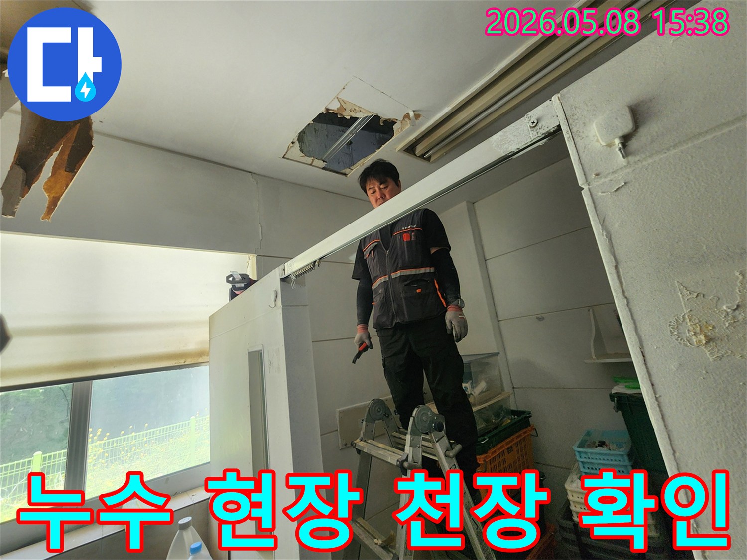숙련된 엔지니어가 사다리를 딛고-천장 손상 부위를-면밀히 관찰하고 있습니다