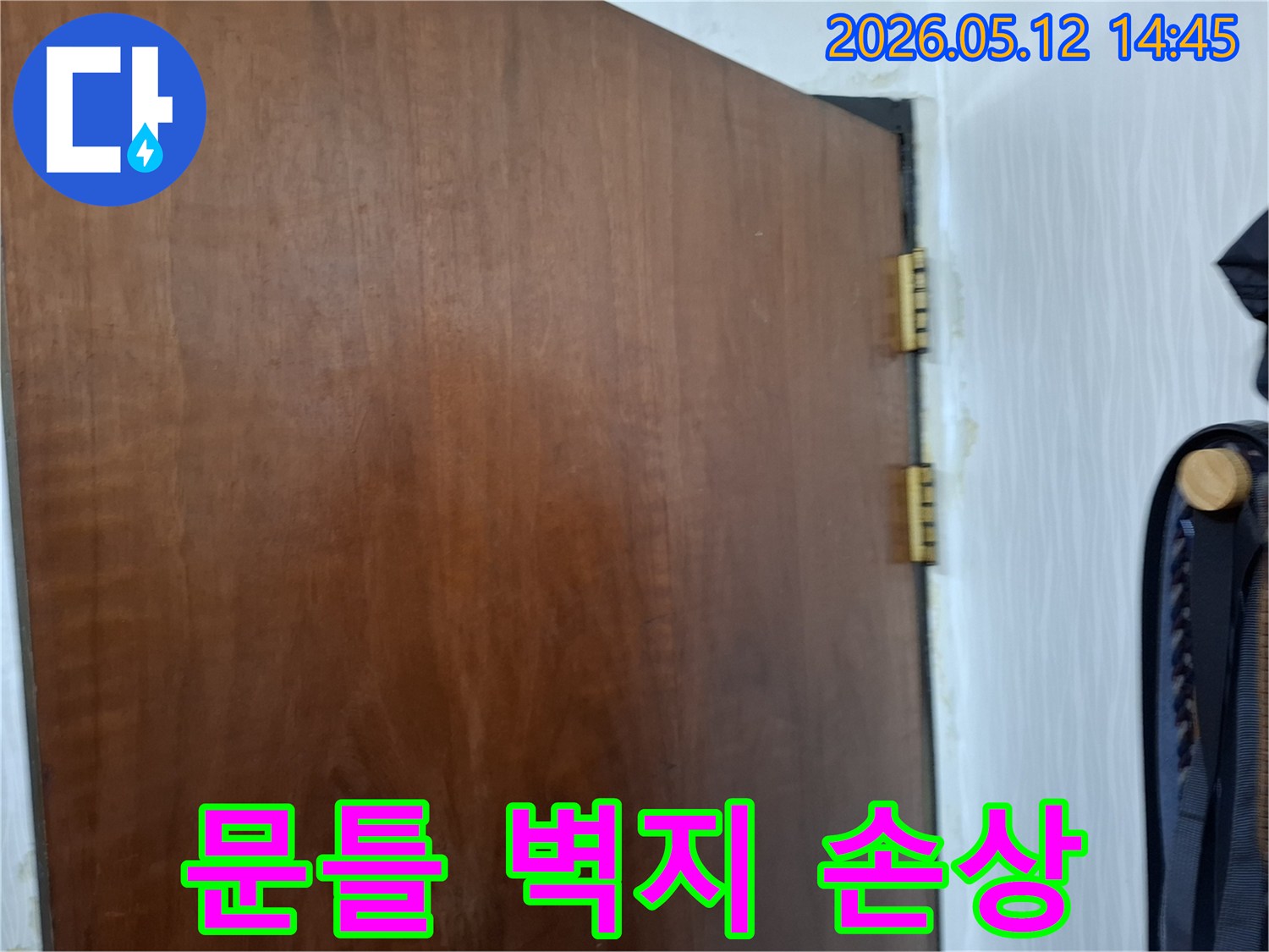 누수로-인해-문틀-주변-벽지가-손상되고-변색된-모습을-보여주는-클로즈업-사진입니다