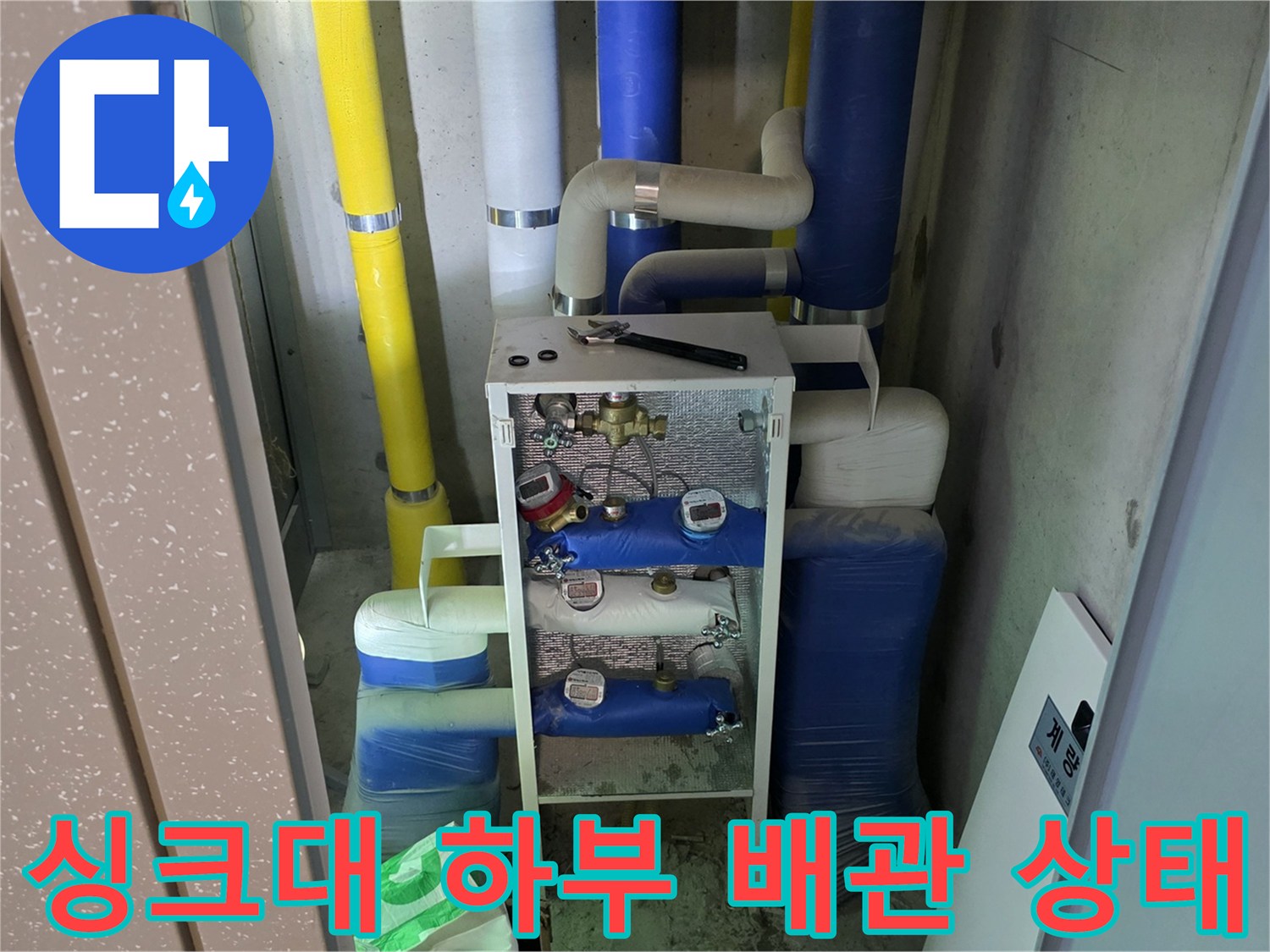 시흥 정왕동 싱크대 하부장 내부의 노후된 보일러 분배기와 배관 연결 부위 모습입니다.